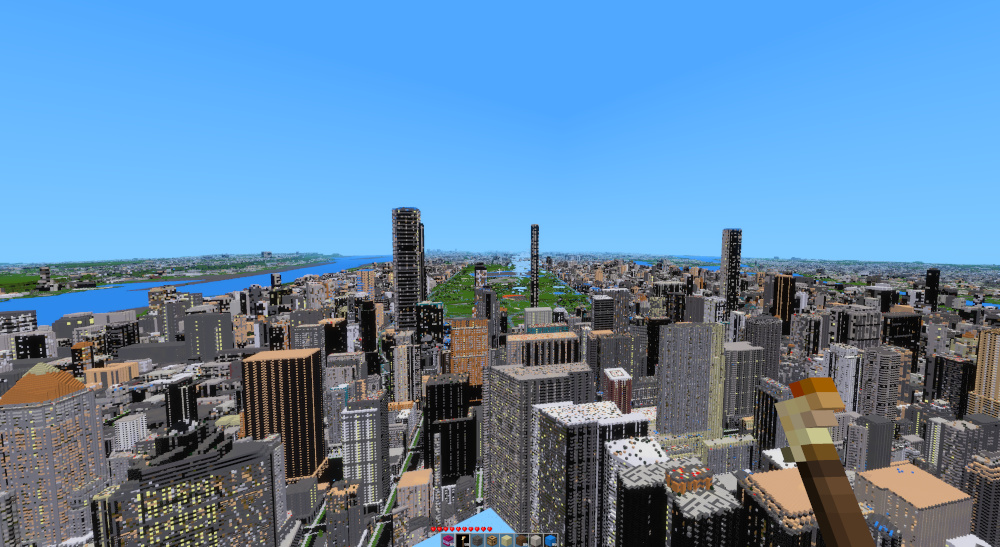 An aerial view of New York recreated in Freeminer, with voxel skyscrapers and rivers beneath a clear blue sky